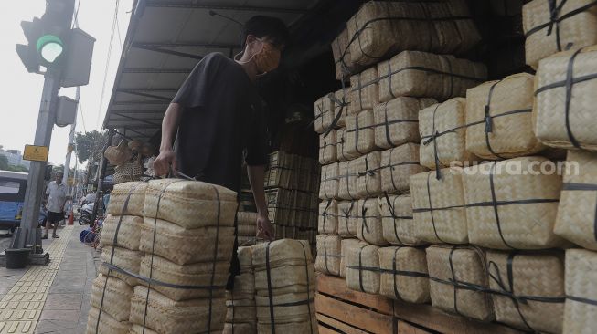 Pedagang membawa besek dari anyaman bambu di Pasar Jatinegara, Jakarta, Rabu (30/6/2021). [Suara.com/Angga Budhiyanto]