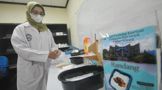 Seorang mahasiswi menyajikan Nasi Padang Instan, di Laboratorium Fakultas Teknologi Pertanian (Fateta), Universitas Andalas (Unand), Padang, Sumatera Barat, Kamis (1/7/2021). ANTARA FOTO/Iggoy el Fitra 