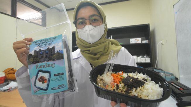 Seorang mahasiswi menunjukan Nasi Padang Instan dalam bentuk kemasan dan yang sudah dipanaskan, di Laboratorium Fakultas Teknologi Pertanian (Fateta), Universitas Andalas (Unand), Padang, Sumatera Barat, Kamis (1/7/2021).. ANTARA FOTO/Iggoy el Fitra
