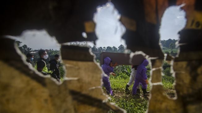 Petugas membawa peti mati jenazah di pemakaman khusus COVID-19 di Cipageran, Cimahi, Jawa Barat, Rabu (30/6/2021). ANTARA FOTO/Novrian Arbi
