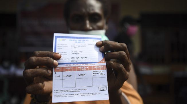 Warga menunjukkan kartu vaksinasi COVID-19 usai menerima suntikan dosis pertama di Agats, Asmat, Papua, Kamis (1/7/2021). [ANTARA FOTO/Puspa Perwitasari]