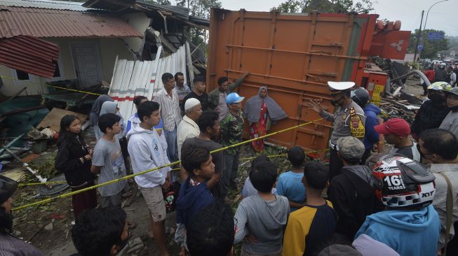 Petugas kepolisian memberikan penjelasan kepada warga yang rumahnya ditabrak truk, di Panyalaian, Kabupaten Tanah Datar, Sumatera Barat, Jumat (2/7/2021). [ANTARA FOTO/Iggoy el Fitra]