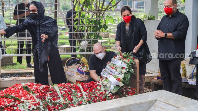 Keluarga dan kerabat berdoa di atas pusara Wakil Ketua Dewan Pembina Partai Gerindra, Rachmawati Soekarnoputri saat dimakamkan di TPU Karet Bivak, Jakarta Pusat, Sabtu (3/7/2021). [Suara.com/Alfian Winanto]