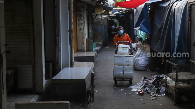 Pedagang membereskan dagangannya di Pasar Tanah Abang, Jakarta Pusat, Sabtu (3/7/2021). [Suara.com/Alfian Winanto]