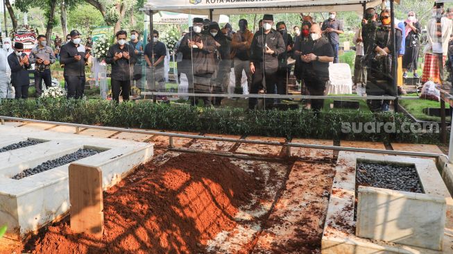 Keluarga dan kerabat berdoa di depan pusara Wakil Ketua Dewan Pembina Partai Gerindra, Rachmawati Soekarnoputri saat dimakamkan di TPU Karet Bivak, Jakarta Pusat, Sabtu (3/7/2021). [Suara.com/Alfian Winanto]