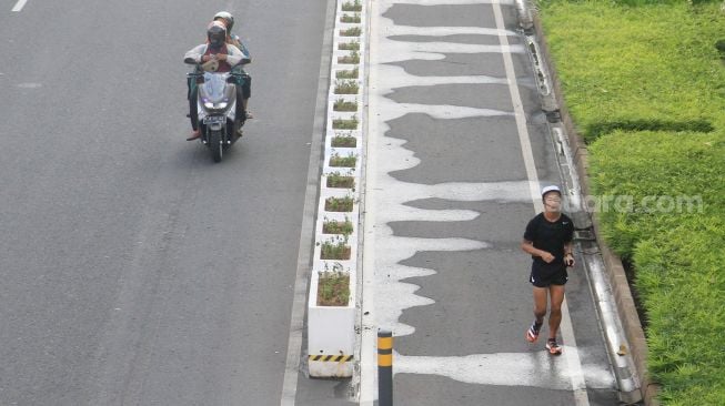 Warga berolahraga di Jalan Jenderal Sudirman, Jakarta, Sabtu (3/7).  [Suara.com/Oke Atmaja]
