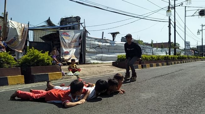 Anak-anak di Cianjur bermain di Jalan HOS Cokroaminoto pada hari pertama pemberlakuan PPKM darurat, Sabut (3/7/2021). [Suara.com/Fauzi Noviandi]