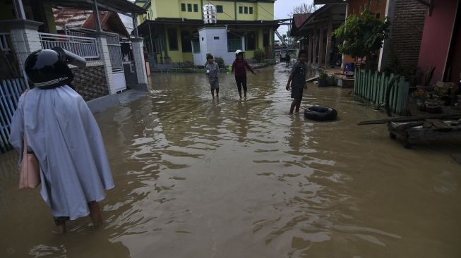 Warga berada di sekitar rumahnya yang terendam banjir di Kampung Baru di Palu, Sulawesi Tengah, Sabtu (3/7/2021). [ANTARA FOTO/Mohamad Hamzah]