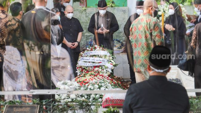 Keluarga dan kerabat berdoa di atas pusara Wakil Ketua Dewan Pembina Partai Gerindra, Rachmawati Soekarnoputri saat dimakamkan di TPU Karet Bivak, Jakarta Pusat, Sabtu (3/7/2021). [Suara.com/Alfian Winanto]