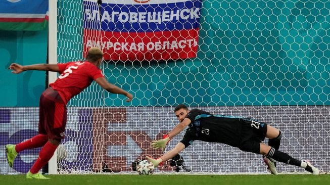 Penjaga gawang Spanyol Unai Simon (kanan) menyelamatkan tendangan bek Swiss Manuel Akanji saat adu penalti di akhir pertandingan sepak bola perempat final EURO 2020 antara Swiss melawan Spanyol di Stadion Saint Petersburg, Jumat (2/6).Dmitri Lovetsky / POOL / AFP