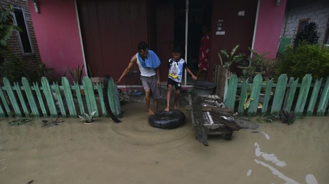 Warga berada di sekitar rumahnya yang terendam banjir di Kampung Baru di Palu, Sulawesi Tengah, Sabtu (3/7/2021). [ANTARA FOTO/Mohamad Hamzah]