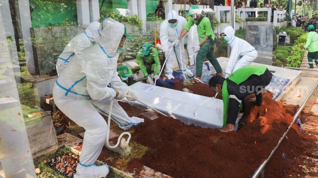 Jenazah Wakil Ketua Dewan Pembina Partai Gerindra, Rachmawati Soekarnoputri diturunkan ke liang lahad saat proses pemakaman di TPU Karet Bivak, Jakarta Pusat, Sabtu (3/7/2021). [Suara.com/Alfian Winanto]