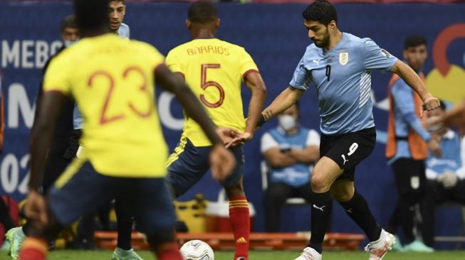 Striker Uruguay Luis Suarez beraksi melewati sejumlah pemain Kolombia. Uruguay harus tersingkir dari Copa America 2021 usai kalah adu penalti dari Kolombia di babak perempatfinal dengan skor 4-2. (Foto: Evaristo SA/AFP)