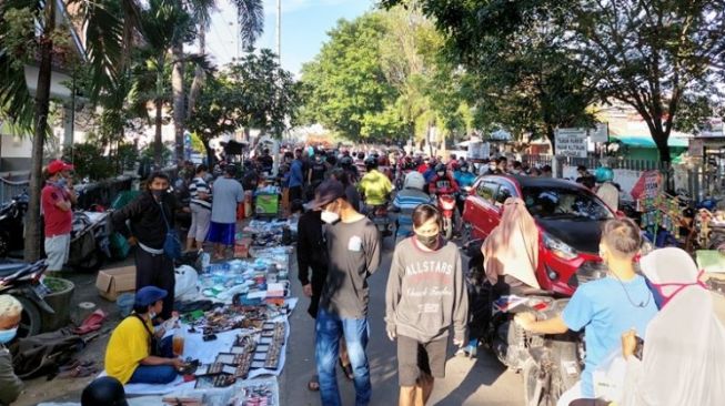 Pedagang Pasar Klitikan Notoharjo berjualan di pinggir jalan dan berkerumun saat PPKM Darurat, Minggu (4/7/2021). [Timlo,net/M Ismail]