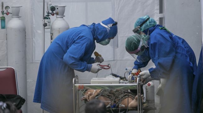 Petugas medis melakukan perawatan pasien di tenda barak yang dijadikan ruang Instalasi Gawat Darurat (IGD) Rumah Sakit Umum Pusat (RSUP) Dr Sardjito, Sleman, DI Yogyakarta, Minggu (4/7/2021). [ANTARA FOTO/Hendra Nurdiyansyah]