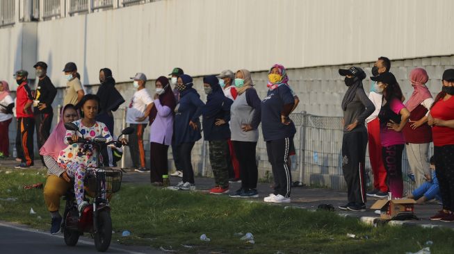 Warga mengikuti senam bersama di hari kedua PPKM Darurat di Jembatan Suramadu, Surabaya, Jawa Timur, Minggu (4/7/2021). [ANTARA FOTO/Didik Suhartono]