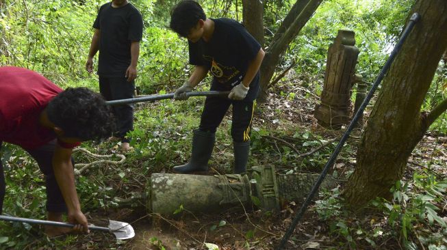 Anggota Masyarakat Peduli Situs Sejarah Aceh (Mapesa) memindahkan sejumlah batu nisan peninggalan sejarah masa Kesultanan Aceh Darussalam abad 18 dan 19 di Desa Lambung Kecamatan Meuraxa, Banda Aceh, Aceh, Minggu (4/7/2021). [ANTARA FOTO/Ampelsa]