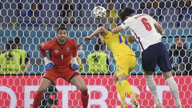 Bek Inggris Harry Maguire (kanan) menyundul bola untuk mencetak gol kedua selama pertandingan sepak bola perempat final UEFA EURO 2020 antara Ukraina dan Inggris di Stadion Olimpiade, Roma, pada (3/7/2021). [ALBERTO LINGRIA / POOL / AFP]