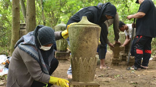 Anggota Masyarakat Peduli Situs Sejarah Aceh (Mapesa) melakukan perawatan dan penataan sejumlah batu nisan peninggalan sejarah masa Kesultanan Aceh Darussalam abad 18 dan 19 di Desa Lambung Kecamatan Meuraxa, Banda Aceh, Aceh, Minggu (4/7/2021). [ANTARA FOTO/Ampelsa]