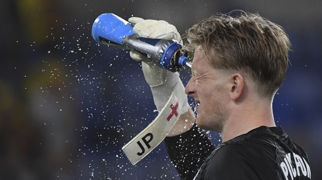 Penjaga gawang Inggris Jordan Pickford melakukan pendinginan selama pertandingan sepak bola perempat final UEFA EURO 2020 antara Ukraina dan Inggris di Stadion Olimpiade, Roma, pada (3/7/2021). [ALBERTO LINGRIA / POOL / AFP]