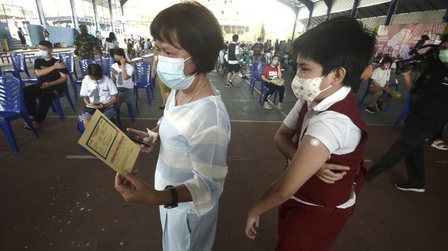 Seorang ibu mendampingi anaknya usai mendapatkan suntikan vaksin COVID-19, di Manado, Sulawesi Utara, Senin (5/7/2021). [ANTARA FOTO/Adwit B Pramono]