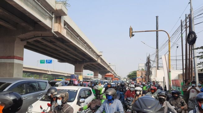 Sejumlah pengendara kendaraan bermotor terjebak kemacetan menjelang pos penyekatan saat PPKM Darurat di Jl. Raya Kalimalang, Jakarta, Senin (5/7/2021). ANTARA/Yogi Rachman