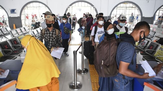 Petugas memeriksa kartu vaksinasi dan syarat lainnya calon penumpang Kereta Api Jayabaya tujuan Malang di Stasiun Pasar Senen, Jakarta, Senin (5/7/2021). [ANTARA FOTO/Hafidz Mubarak A]