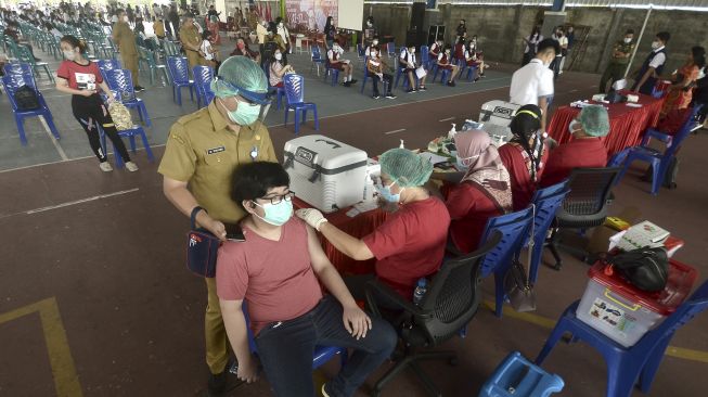 Orang tua mendampingi murid mendapatkan suntikan vaksin COVID-19, di Manado, Sulawesi Utara, Senin (5/7/2021). [ANTARA FOTO/Adwit B Pramono]