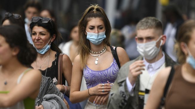 Pembeli mengenakan masker saat berjalan di sepanjang Oxford Street, Kota London, pada (5/7/2021). [DANIEL LEAL-OLIVAS / AFP]