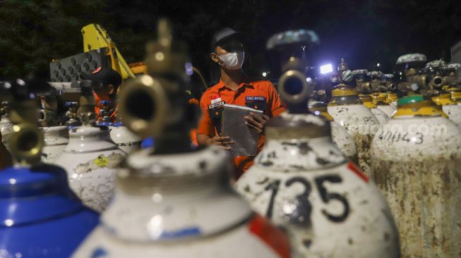 Petugas mendata tabung oksigen yang ada di Posko Darurat Oxygen Rescue di kawasan Monumen Nasional (Monas), Jakarta Pusat, Selasa (6/7/2021). [Suara.com/Alfian Winanto]