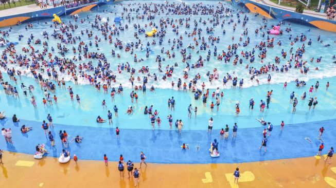 Foto udara menunjukkan orang-orang bersantai di kolam renang di Lianyungang, Provinsi Jiangsu Timur, China, pada (4/7/2021). [STR / AFP]