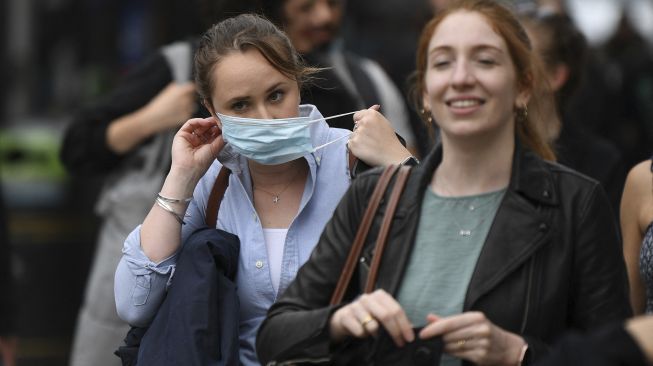 Pembeli mengenakan masker saat berjalan di sepanjang Oxford Street, Kota London, pada (5/7/2021). [DANIEL LEAL-OLIVAS / AFP]