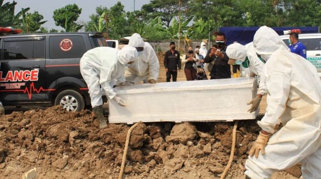 Petugas tengah melakukan pemakaman dengan protokol COVID-19 di TPU Rorotan, Jakarta Utara, Selasa (6/7/2021). [Instagram@arizapatria]