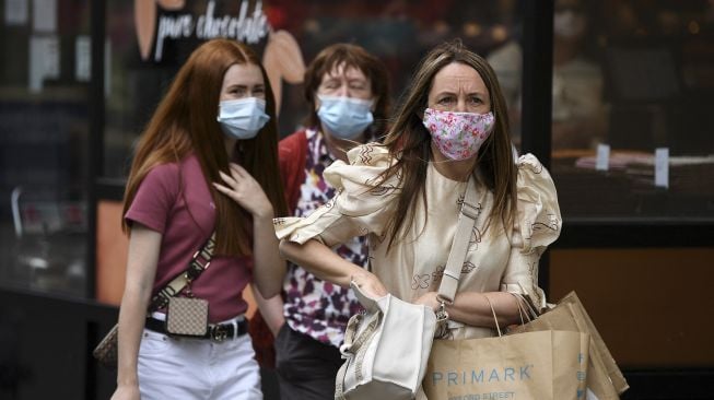 Pembeli mengenakan masker saat berjalan di sepanjang Oxford Street, Kota London, pada (5/7/2021). [DANIEL LEAL-OLIVAS / AFP]