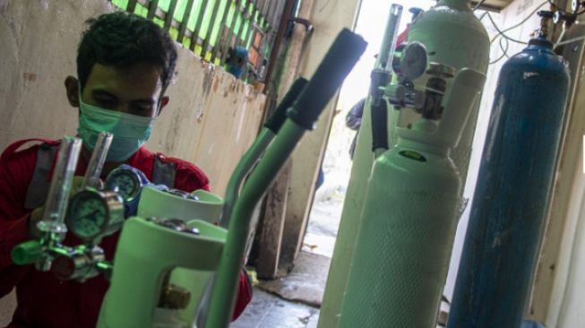 Pekerja mengisi ulang tabung oksigen di toko Alat Kesehatan (Alkes) Amifa Medika Palembang, Sumatera [ANTARA]