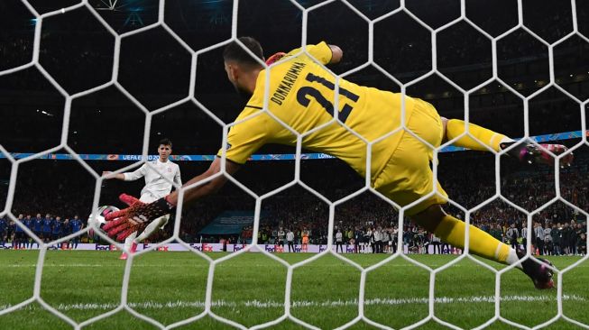 Penjaga gawang Italia, Gianluigi Donnarumma menggagalkan eksekusi striker Spanyol Alvaro Morata, dalam adu penalti di semifinal UEFA EURO 2020 antara Italia vs Spanyol, di Stadion Wembley London, Inggris, Rabu (7/7) dini hari WIB.  [Photo/AFP]