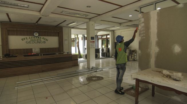 Pekerja menyelesaikan persiapan RS Darurat COVID-19 di Kompleks Asrama Haji, Pondok Gede, Jakarta, Rabu (7/7/2021). ANTARA FOTO/Asprilla Dwi Adha