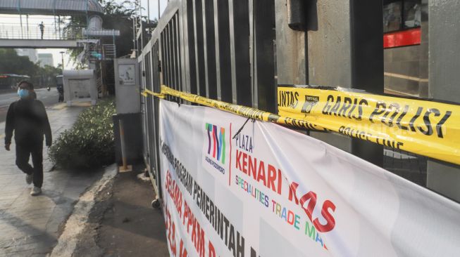 Garis polisi menyegel pintu depan Plaza Kenari Mas di kawasan Senen, Jakarta Pusat, Kamis (8/7/2021). [Suara.com/Alfian Winanto]