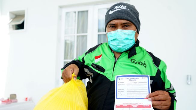 Sejumlah pengendara ojek online antre menunjukan paket bahan pokok usai mengikuti vaksinasi COVID-19 di Bele Li Mbui, Kota Gorontalo, Gorontalo, Kamis (8/7/2021).  ANTARA FOTO/Adiwinata Solihin