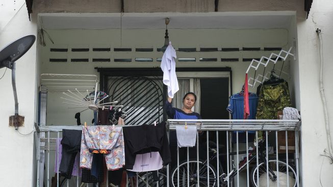 Seorang janda, Tilda Kalaivani melambaikan kemeja sebagai bendera putih untuk meminta bantuan setelah terdampak pandemi COVID-19 di apartemen sewaannya di Kuala Lumpur, Malaysia, pada (6/7/2021). [Mohd RASFAN / AFP]