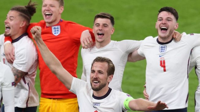 Penyerang Timnas Inggris, Harry Kane (tengah depan) dan rekan-rekannya merayakan keberhasilan timnya melaju ke final Euro 2020 usai mengalahkan Denmark di Stadion Wembley, London, Kamis (8/7/2021) dini hari WIB. Catherine Ivill / POOL / AFP.