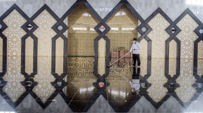 Petugas membersihkan Masjid Baitul Faidzin, Cibinong, Kabupaten Bogor, Jawa Barat, Jumat (9/7/2021).  ANTARA FOTO/Yulius Satria Wijaya