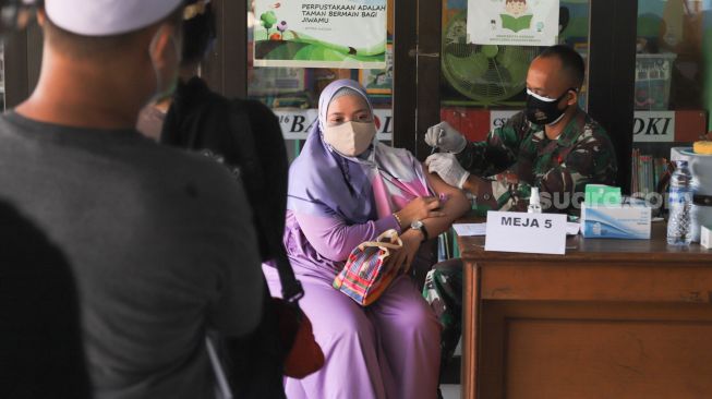 Warga menjalani vaksinasi di RPTRA Kalijodo, Jakarta Barat, Jumat (9/7/2021). [Suara.com/Alfian Winanto]