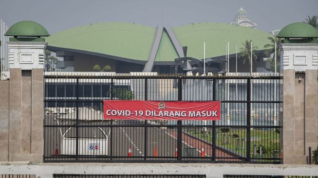 Spanduk bertulis "COVID-19 Dilarang Masuk" terpasang di pagar kompleks Parlemen, Jakarta, Jumat (9/7/2021).  ANTARA FOTO/Aditya Pradana Putra.