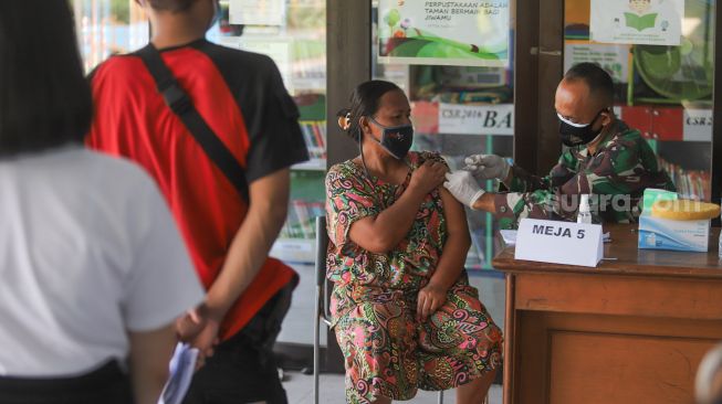 Warga menjalani vaksinasi di RPTRA Kalijodo, Jakarta Barat, Jumat (9/7/2021). [Suara.com/Alfian Winanto]