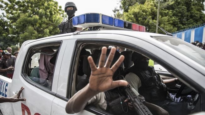 Dua pria, yang dituduh terlibat dalam pembunuhan Presiden Jovenel Moise, diangkut menuju kantor Polisi Petionville dengan mobil polisi di Port au Prince, Haiti, pada (8/7/2021). [Valerie Baeriswyl / AFP]