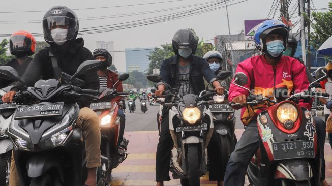 Pengendara motor berhenti sejenak untuk mengheningkan cipta di kawasan Cilandak, Jakarta Selatan, Sabtu (10/7/2021). [Suara.com/Alfian Winanto]