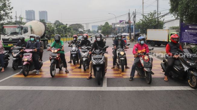 Pengendara motor berhenti sejenak untuk mengheningkan cipta di kawasan Cilandak, Jakarta Selatan, Sabtu (10/7/2021). [Suara.com/Alfian Winanto]