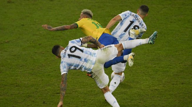 Pemain Argentina Nicolas Otamendi (kiri) dan pemain Argentina Guido Rodriguez bertabrakan dengan pemain Brasil Neymar selama pertandingan final turnamen sepak bola Copa America 2021 Conmebol di Stadion Maracana, Rio de Janeiro, Brasil, pada (10/7/2021). [MAURO PIMENTEL / AFP]