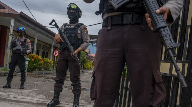 Polisi berjaga di depan gerbang Rumah Sakit Bhayangkara yang akan menjadi lokasi identifikasi dua jenazah dari kelompok DPO Mujahidin Indonesia Timur (MIT) Poso di Palu, Sulawesi Tengah, Minggu (11/7/2021). [ANTARA FOTO/Basri Marzuki]